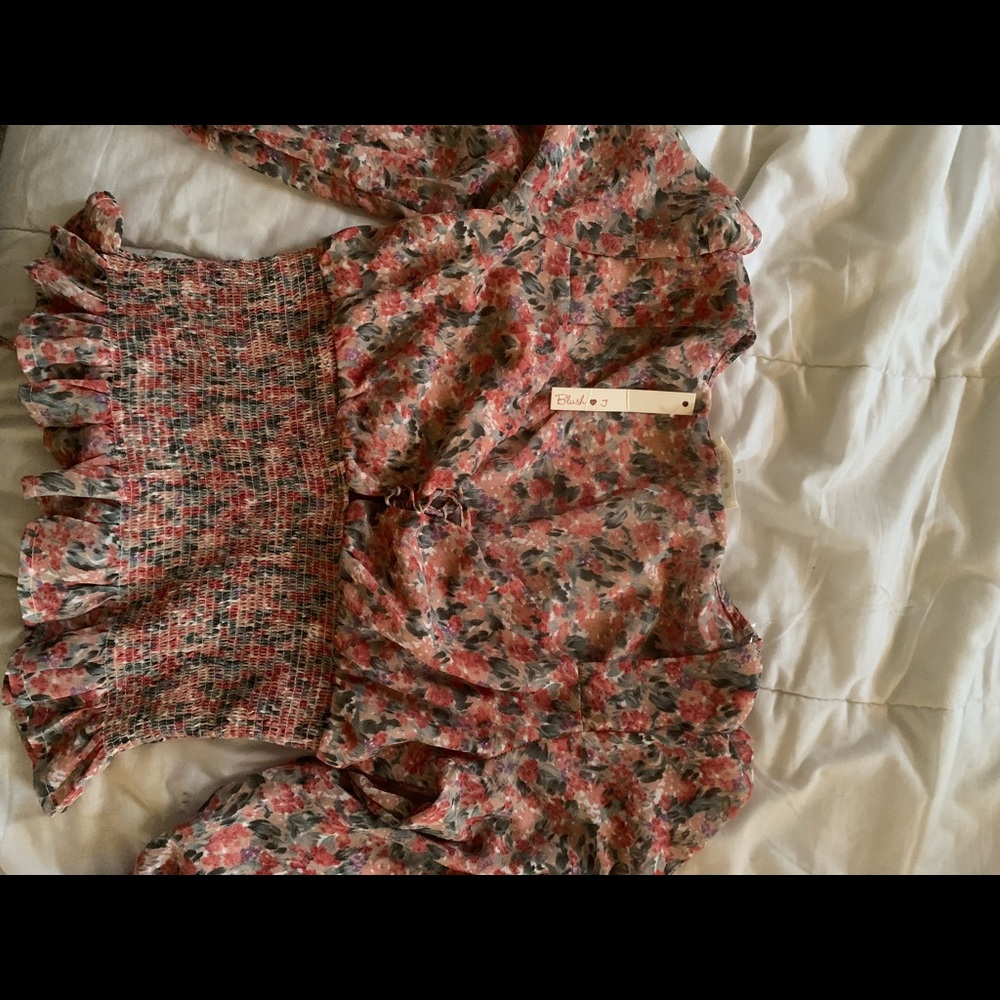 Pink top with multicolor floral pattern.